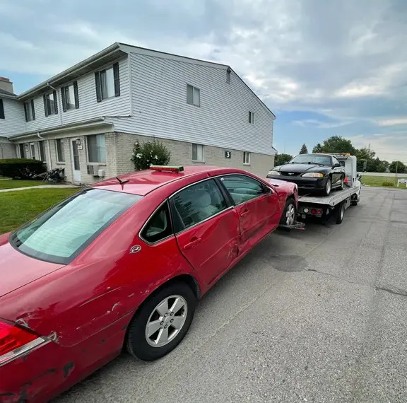 A red car is parked in front of a house.