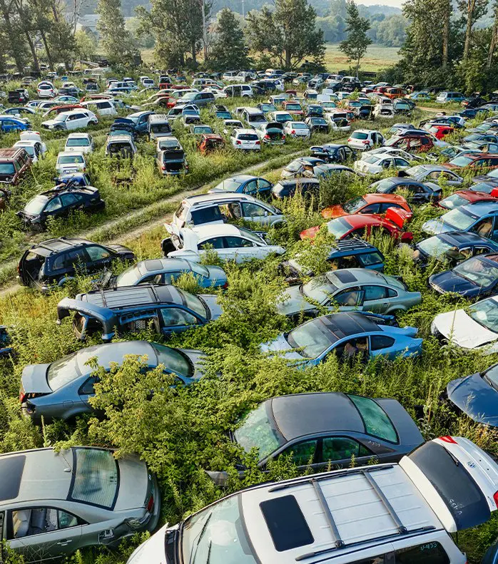 A field full of cars that are parked in the grass.
