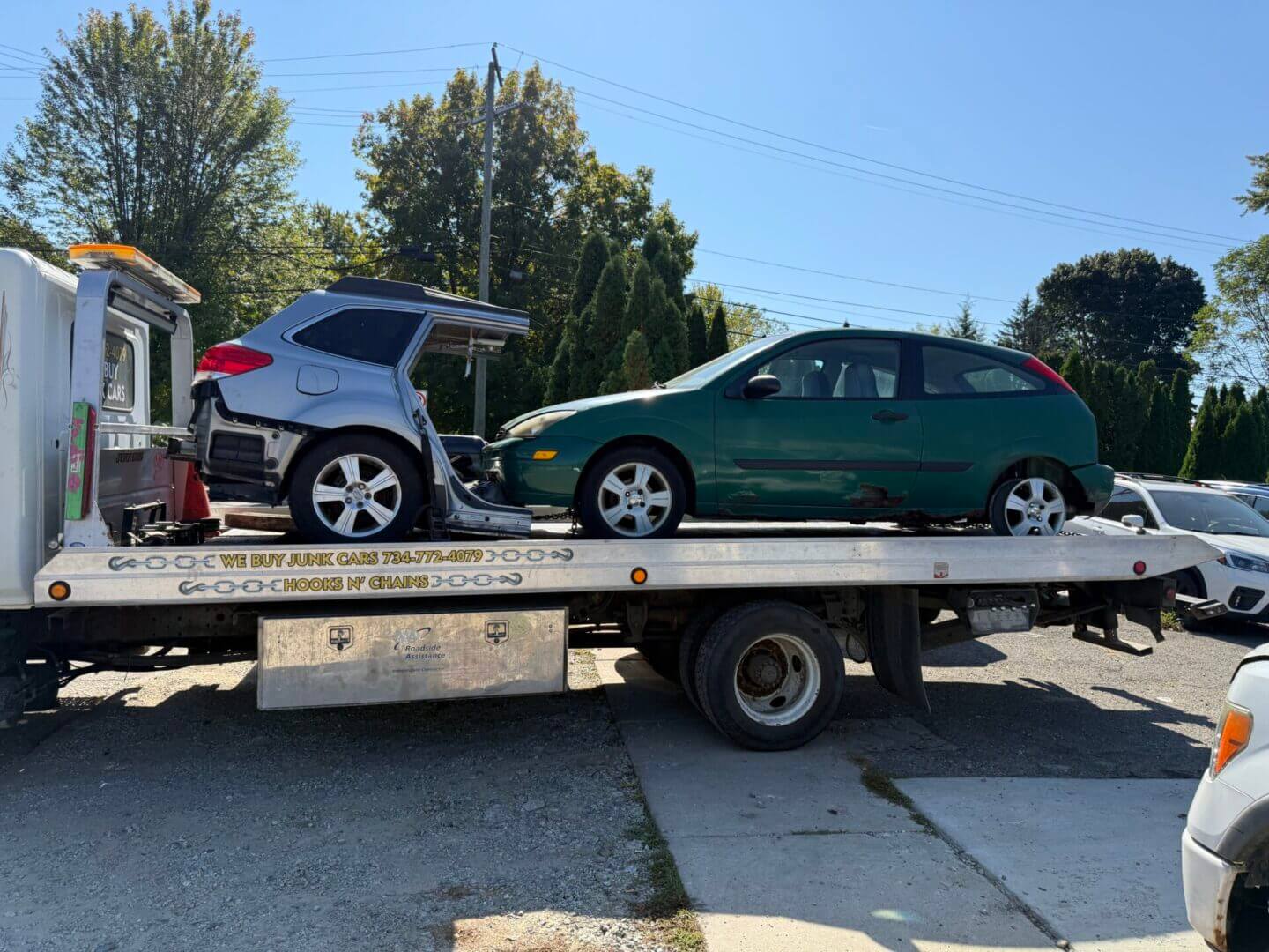 Two cars on a flatbed tow truck.